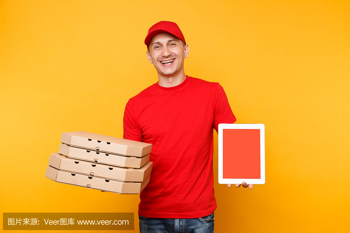 送餐员穿着红帽t恤,在黄色背景的扁平盒子里送外卖比萨。男员工披萨快递员手持平板电脑电脑与空白空白屏幕样机。服务的概念。